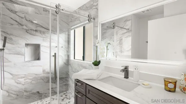 a bathroom with a granite countertop shower sink and mirror