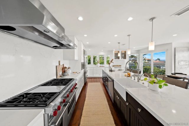 a large kitchen with stainless steel appliances and a view of living room