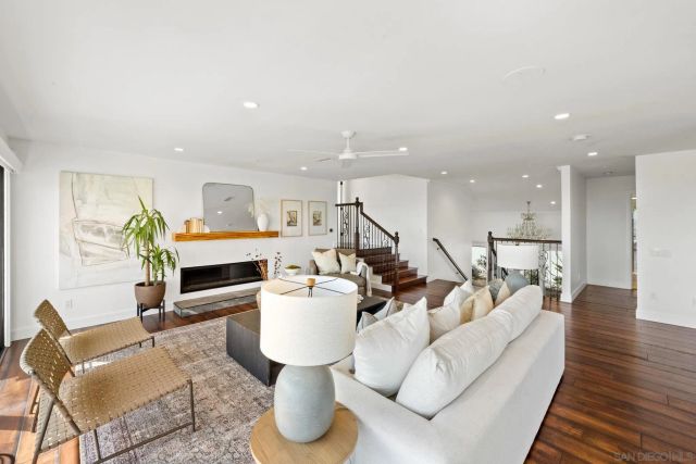 a living room with furniture a fireplace and a large window