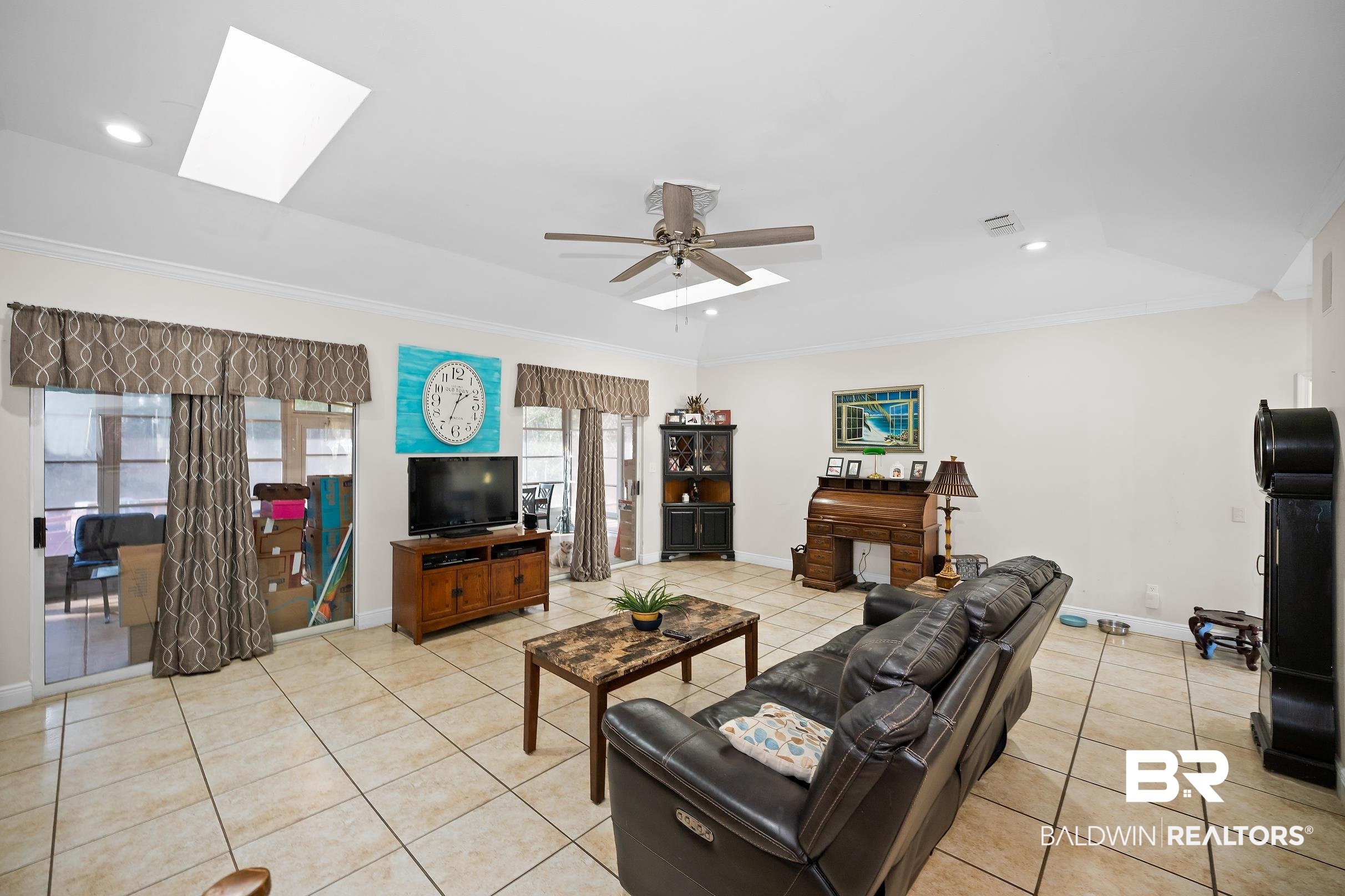 2674 Pine Ridge Drive Lillian, AL 36549 - Photo 3 of 42 Living room with a skylight, light tile patterned floors, recessed lighting, crown molding, and ceiling fan