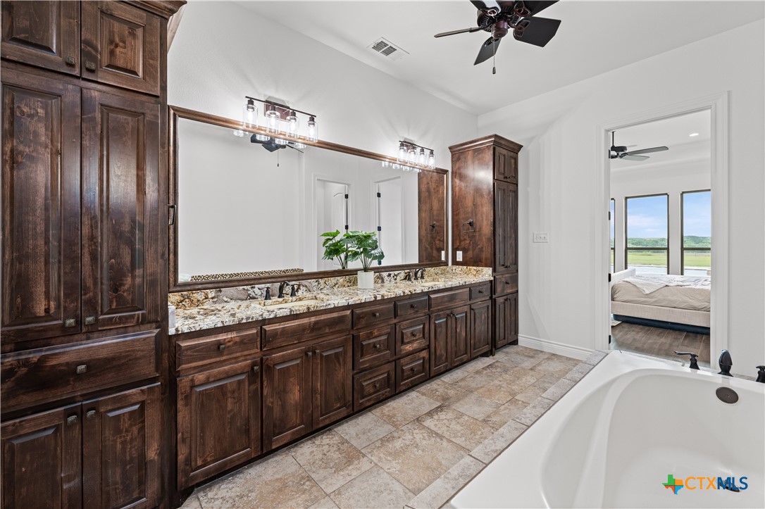 11023 Bigham Road Troy, TX 76579 - Photo 22 of 42 a spacious bathroom with a tub double sink window and a mirror