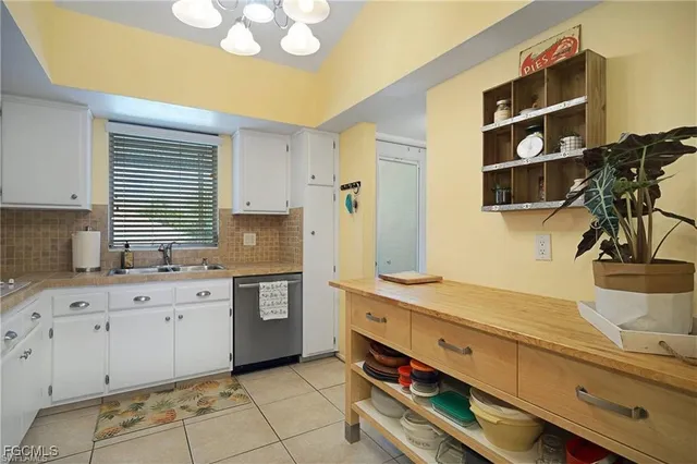 a kitchen with a sink a refrigerator a microwave and cabinets