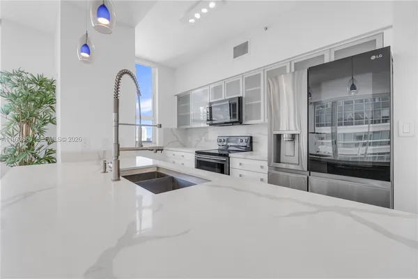a kitchen with granite countertop a stove and a microwave