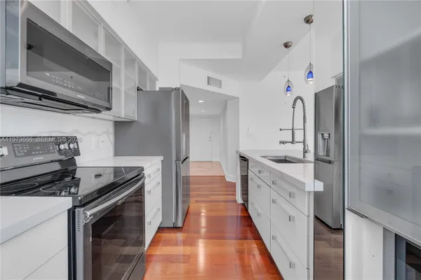 a kitchen with stainless steel appliances a stove microwave and cabinets