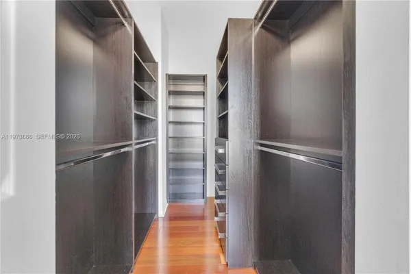 a view of walk in closet with clothes and shoes