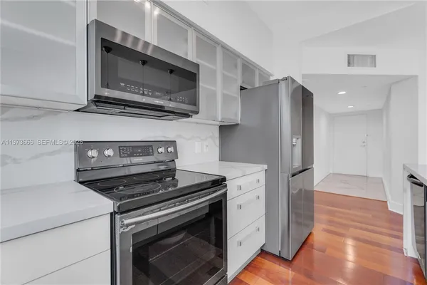 a kitchen with stainless steel appliances a stove a microwave and a refrigerator