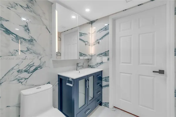 a bathroom with a sink a toilet and a mirror