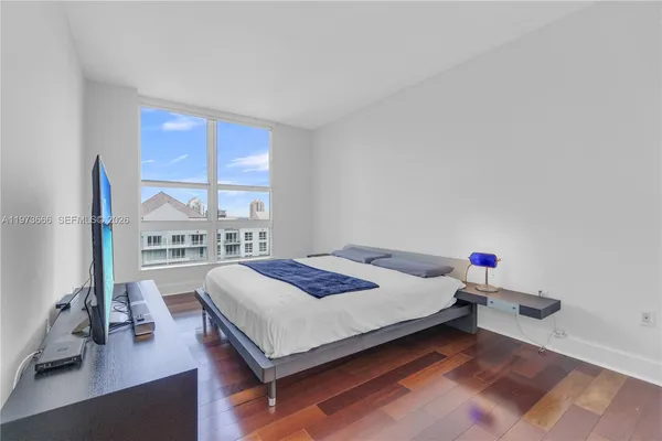 a bedroom with a bed and a large window