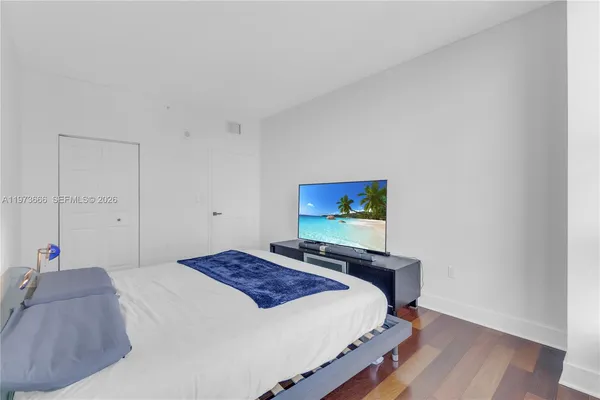 a bedroom with a bed and a flat screen tv