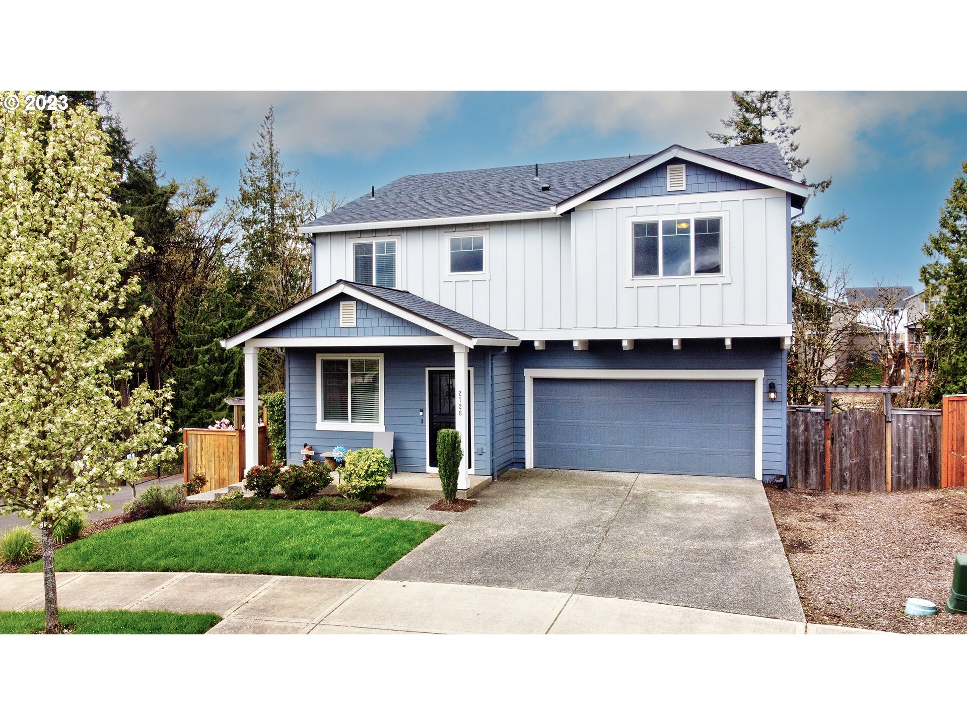 a front view of a house with a yard and trees