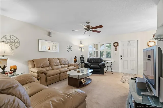 a living room with furniture ceiling fan and a window