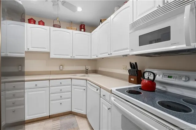 a kitchen with white cabinets and sink