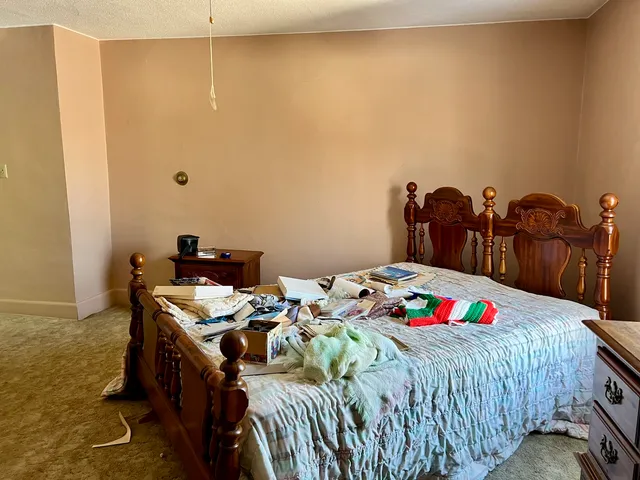 a bedroom with a bed dresser and a window