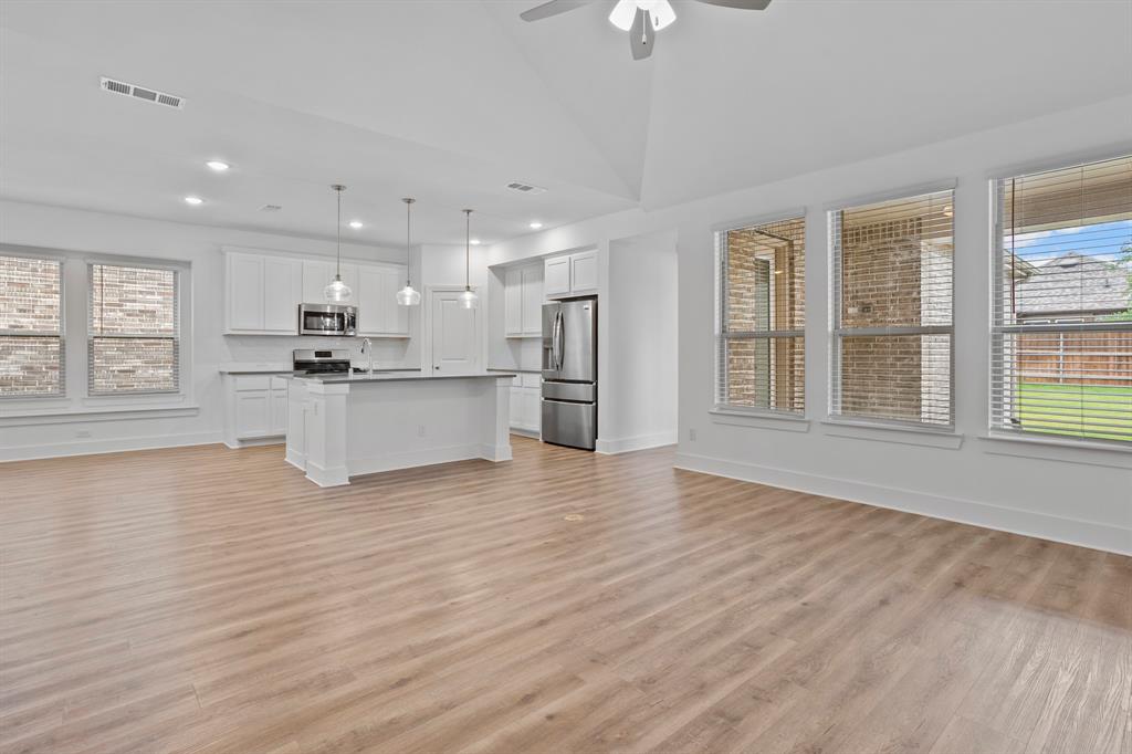 1801 Eagle Landing Van Alstyne, TX 75495 - Photo 27 of 27 Kitchen featuring stainless steel appliances, open floor plan, light wood-type flooring, white cabinets, and a ceiling fan