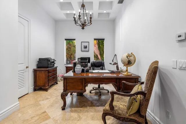 an empty room with windows and chandelier