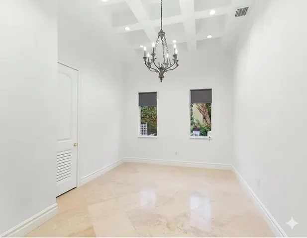 a living room with furniture a flat screen tv and a chandelier