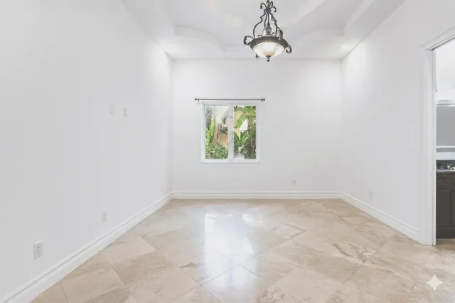 an empty room with a chandelier fan