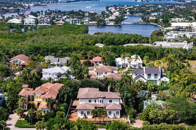 an aerial view of residential houses with outdoor space and trees