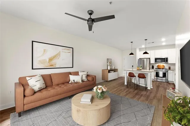 a living room with furniture and a view of kitchen