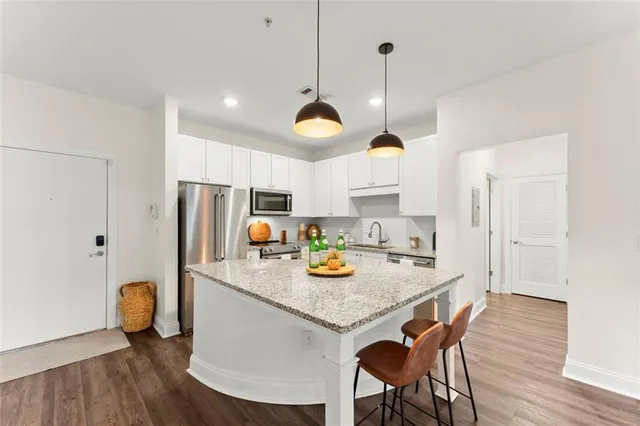 a kitchen with a dining table chairs and refrigerator