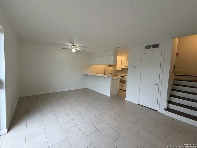 a view of a kitchen with a sink and an empty room