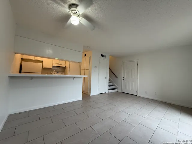 a view of a room with a ceiling fan and window