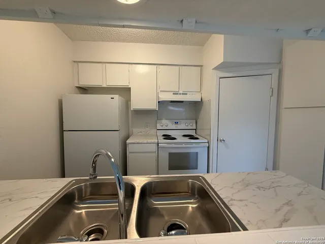 a kitchen with a refrigerator and a sink
