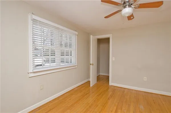 a view of an empty room with a window and wooden floor