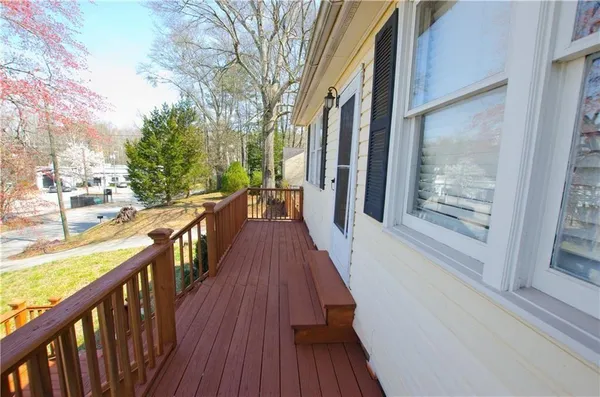 a view of a balcony with wooden floor and bench