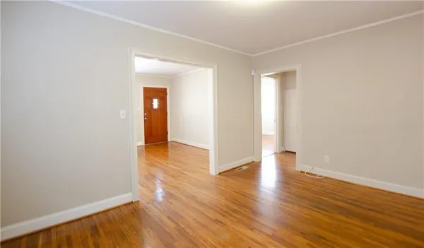 a view of an empty room with wooden floor