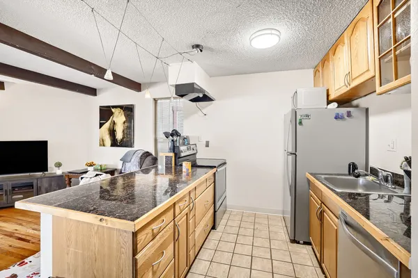 a kitchen with stainless steel appliances granite countertop a sink a counter space and cabinets