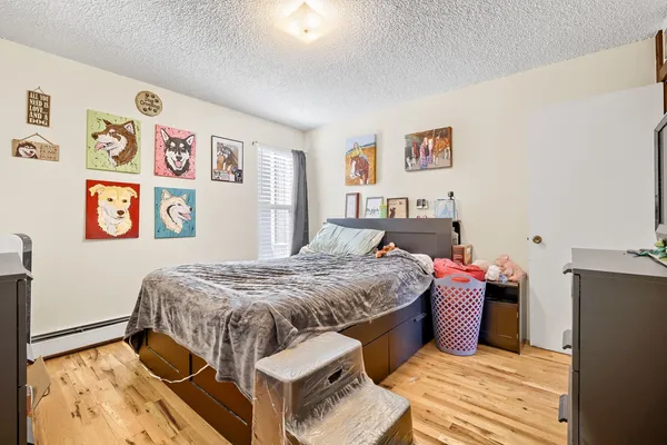 a bedroom with a bed and wooden floor