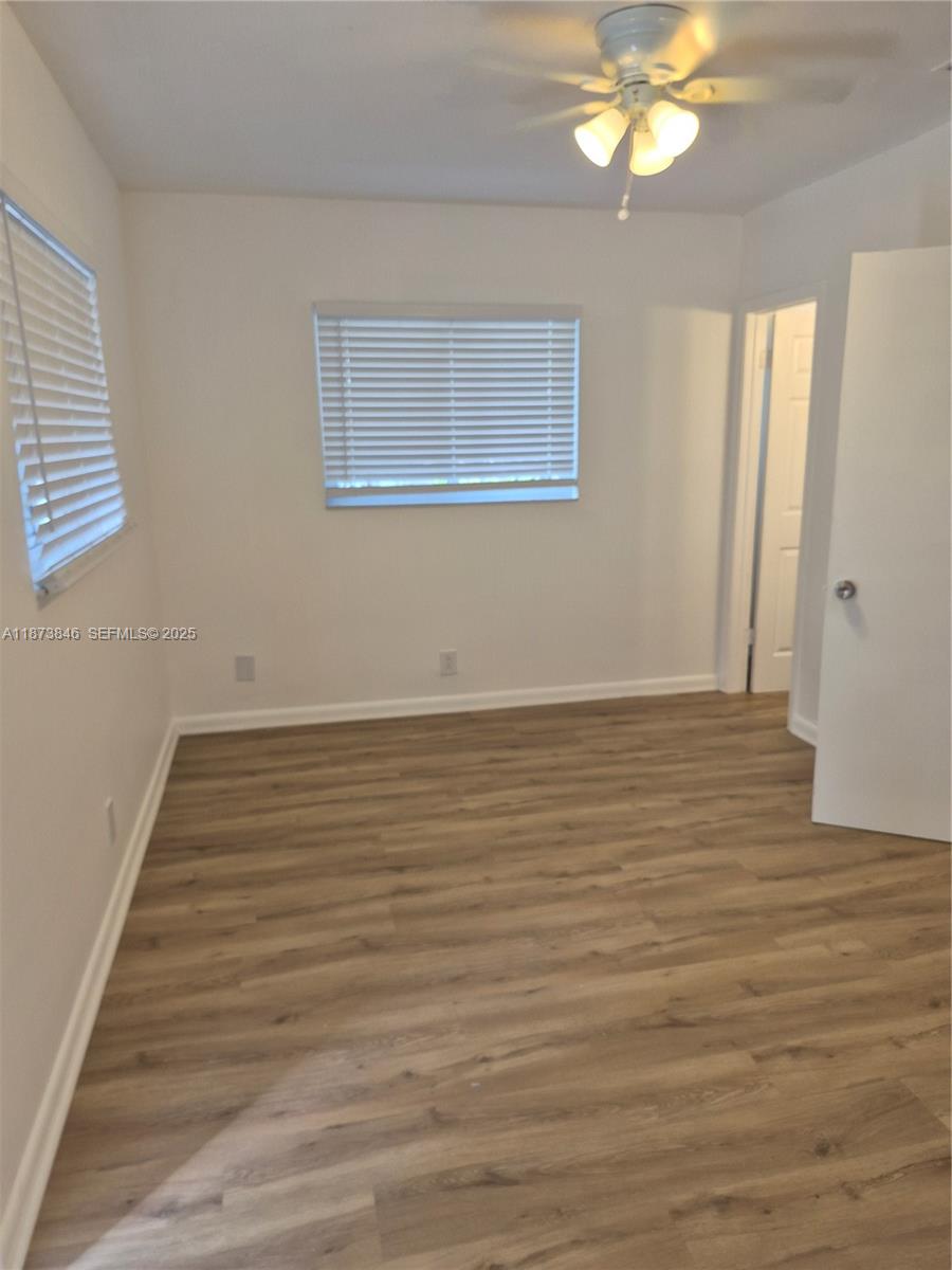 216 Southwest 9th Street, Unit 2 Hallandale Beach, FL 33009 - Photo 8 of 19 a view of an empty room with wooden floor and a window