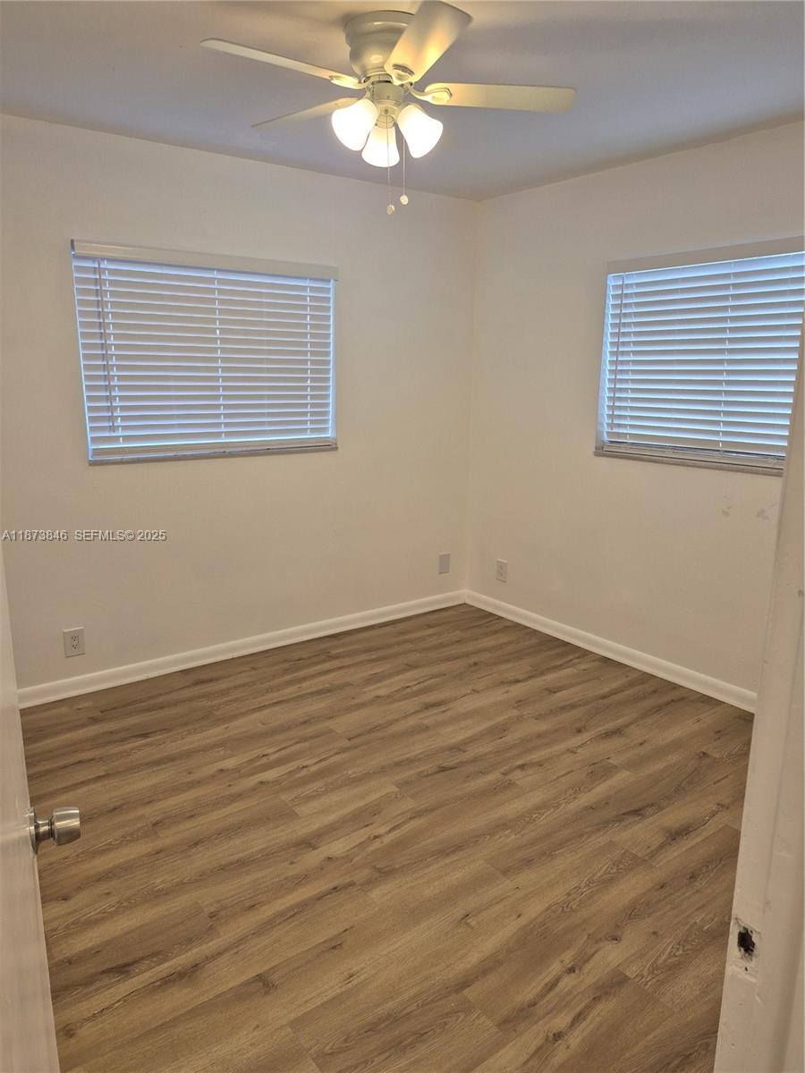 216 Southwest 9th Street, Unit 2 Hallandale Beach, FL 33009 - Photo 10 of 19 a view of an empty room with wooden floor and a window