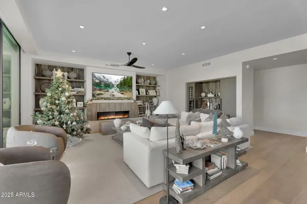 a living room with fireplace furniture and a large window