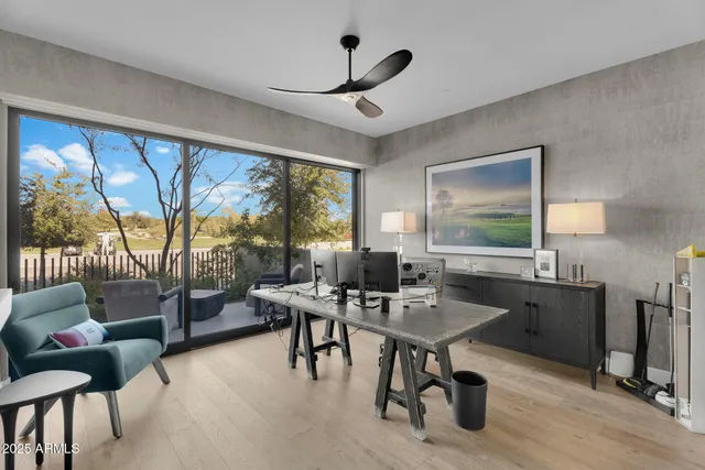 a workspace with furniture and a large window