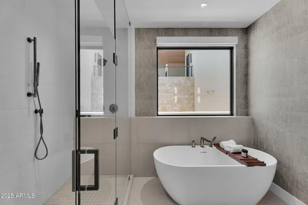 a bathroom with a tub sink shower and mirror