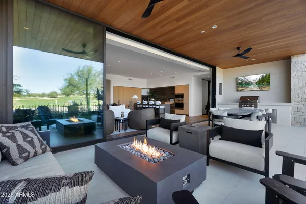 a living room with couches a flat screen tv and kitchen view