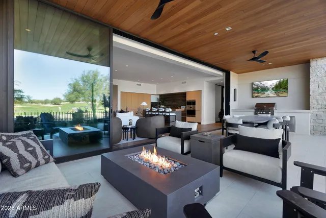 a living room with couches a flat screen tv and kitchen view