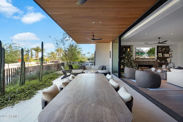 a living room with patio furniture and a potted plant