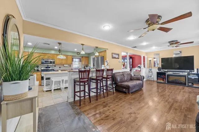 a living room with furniture and a flat screen tv with kitchen view