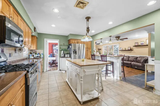 a kitchen with granite countertop stainless steel appliances a sink a counter top space cabinets and a window