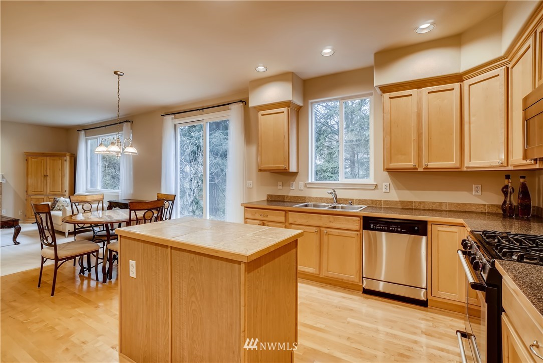 111 203rd Street Southeast Bothell, WA 98012 - Photo 11 of 31 a kitchen with stainless steel appliances granite countertop a stove a sink a microwave a dining table and chairs