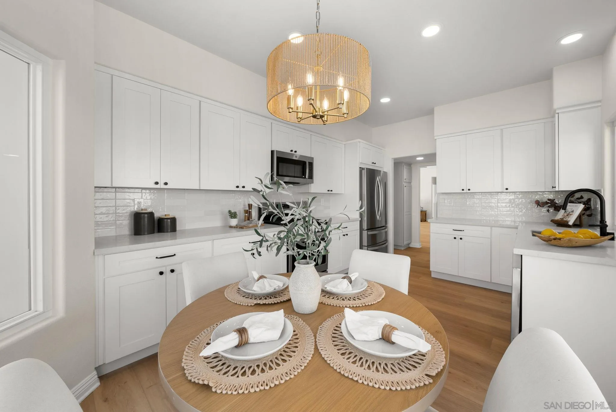 4957 Lamia Way Oceanside, CA 92056 - Photo 13 of 31 a kitchen with stainless steel appliances granite countertop a sink a stove a dining table and chairs