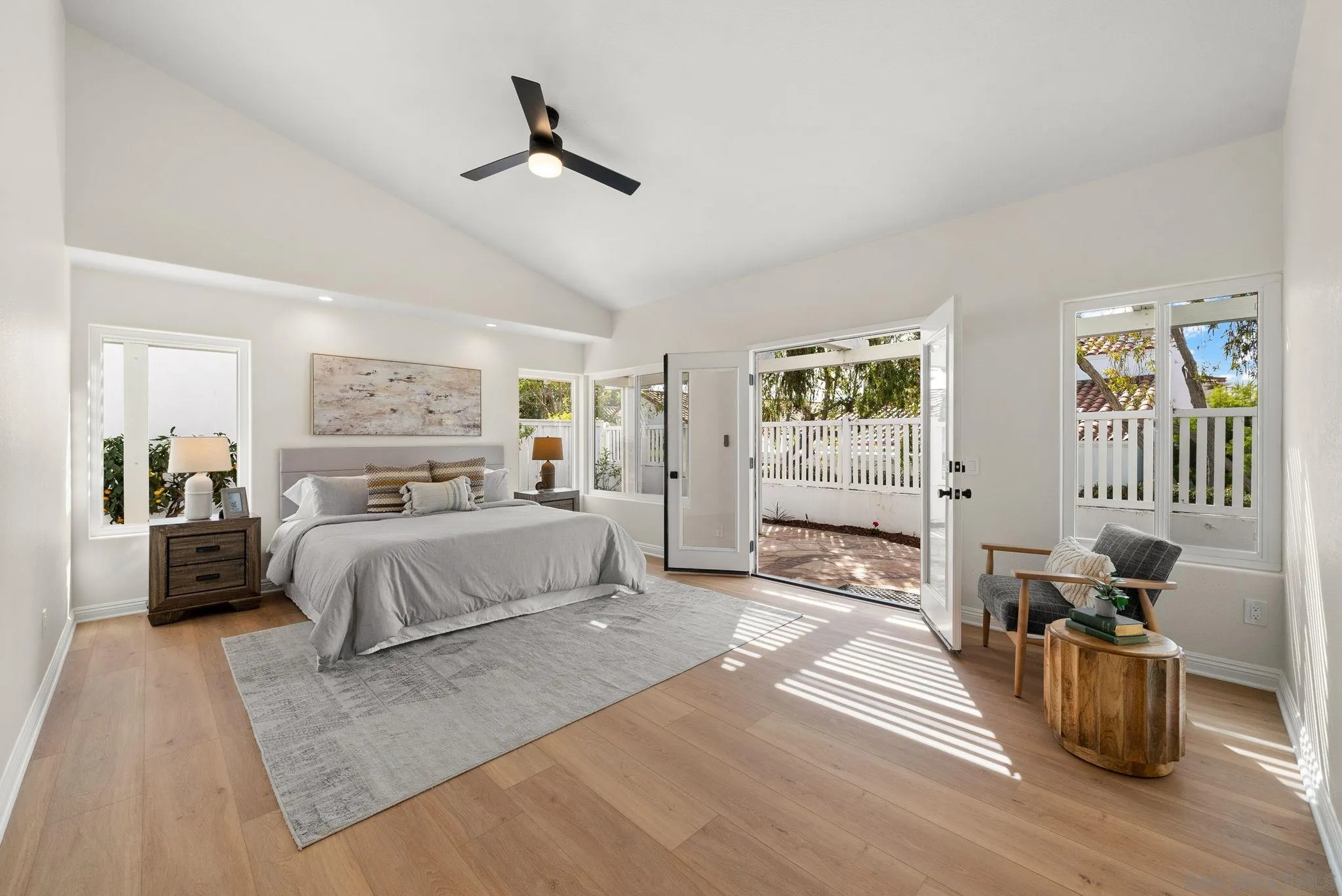 4957 Lamia Way Oceanside, CA 92056 - Photo 17 of 31 a spacious bedroom with a large bed a chandelier and windows