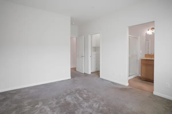 a bedroom with a bed a mirror on dresser and a chandelier
