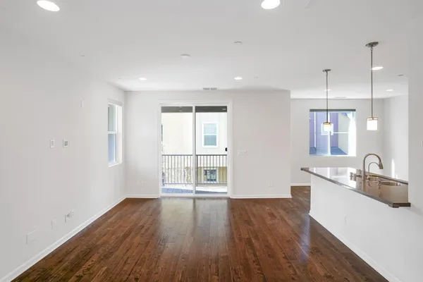 a view of a kitchen and a sink with wooden floor