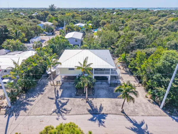 an aerial view of a house with yard and seating space
