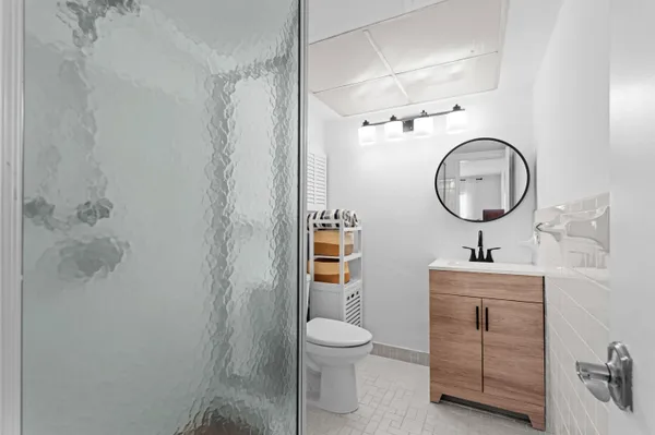 a bathroom with a toilet sink vanity and mirror
