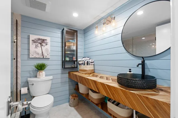 a bathroom with a toilet a sink and mirror